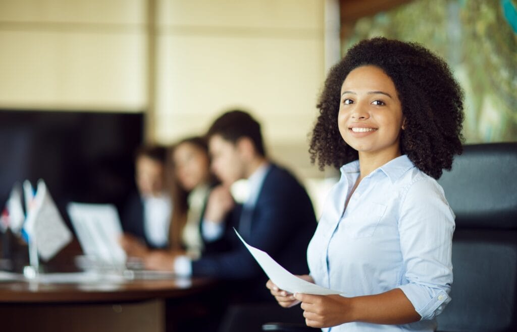 female employee happy smiling with colleagues blurred shade | Brazil Economy
